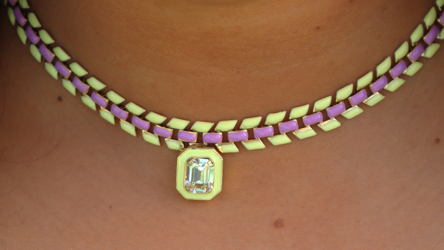 Woman wearing a purple and yellow painted gold-plated chain necklace with a center Swarovski crystal pendant.
