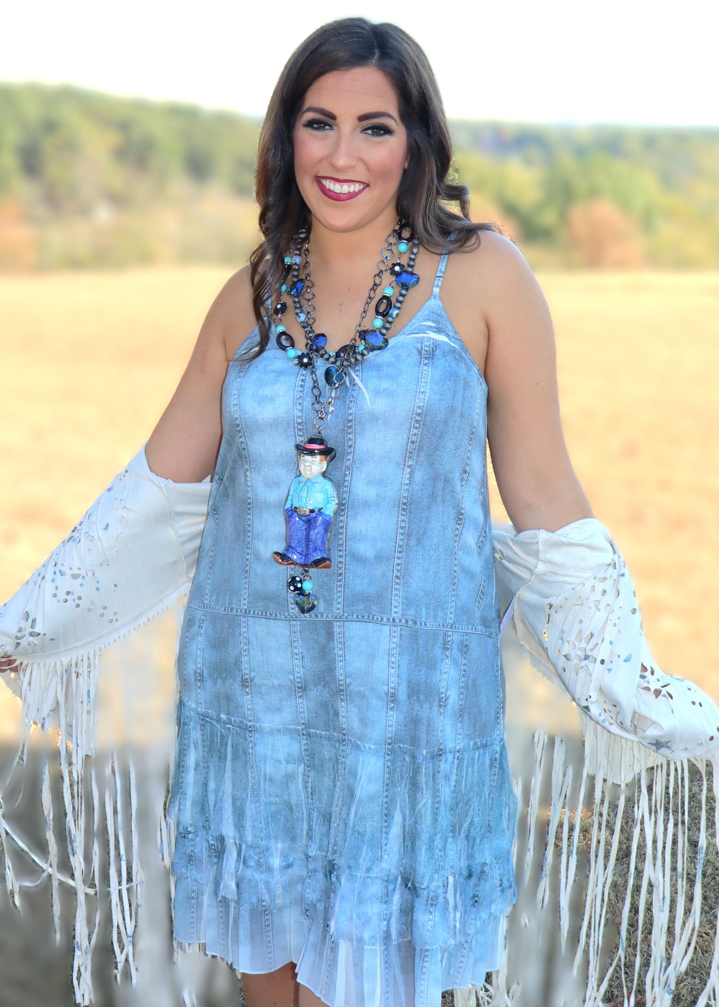 Woman wearing a denim print slip dress with a scenic background