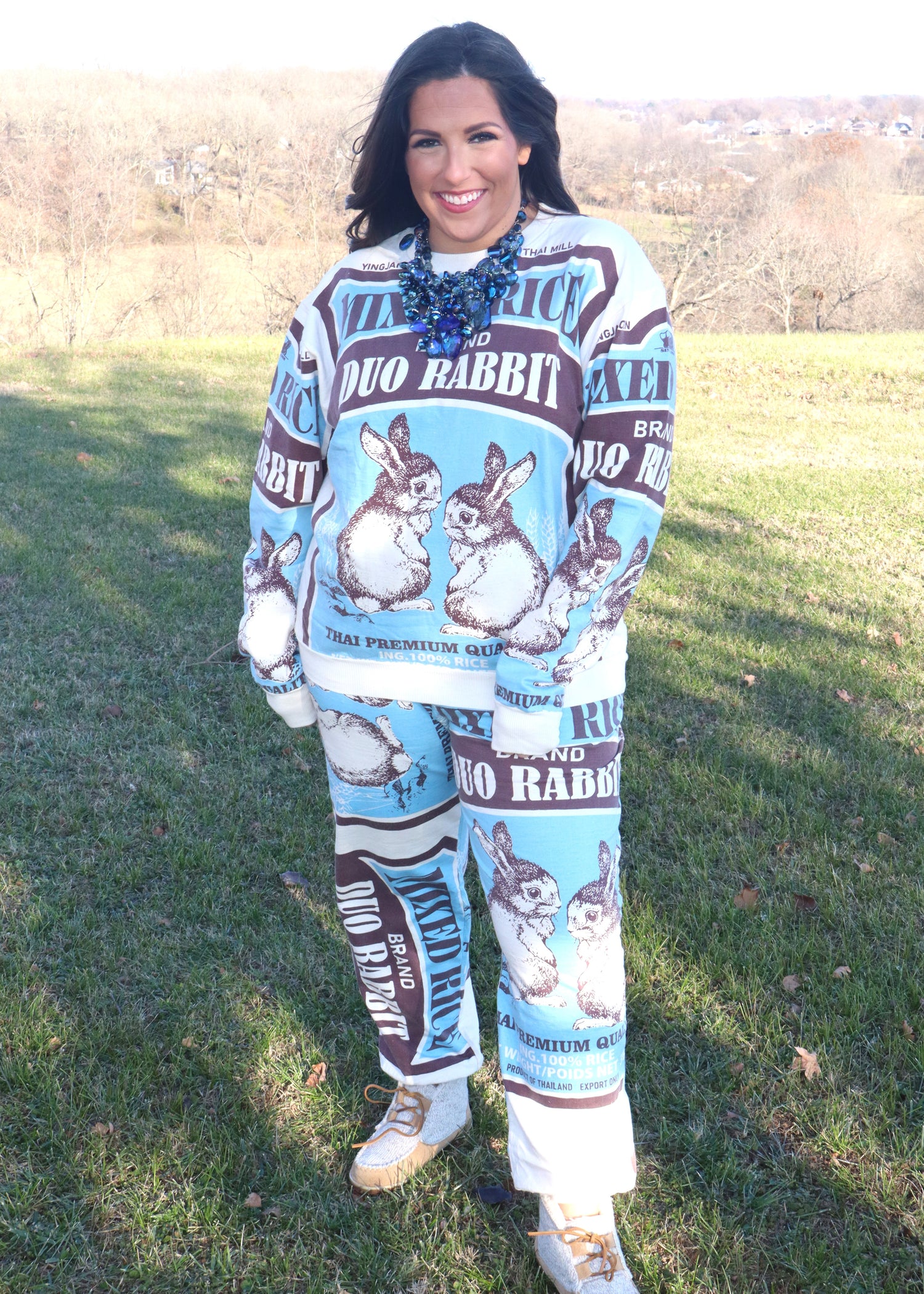 Woman wearing a blue and black matching set with rabbit design outdoors.