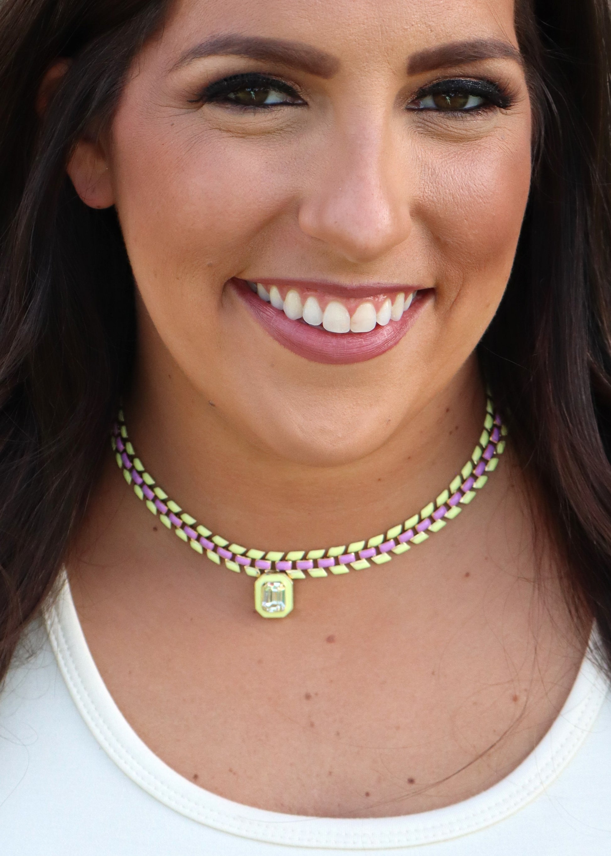 Woman wearing a purple and yellow painted gold-plated chain necklace with a center Swarovski crystal pendant.