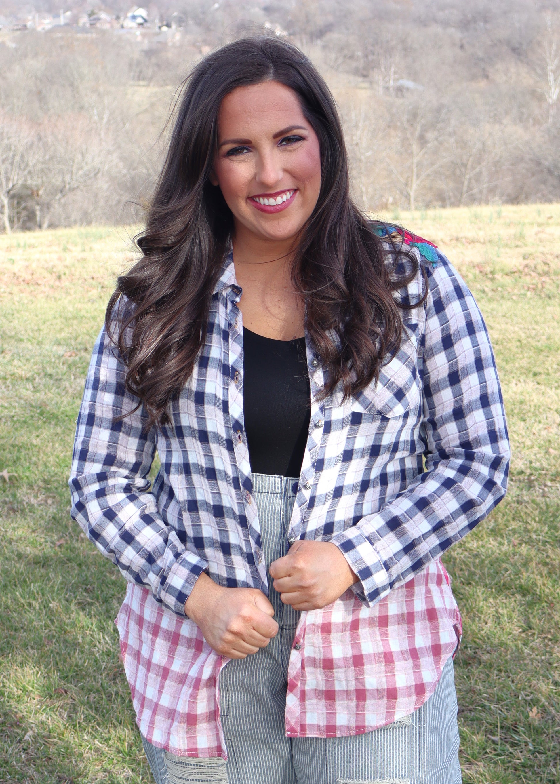 Woman wearing floral velvet applique-details on a plaid shirt with navy to red ombre effect while standing outside