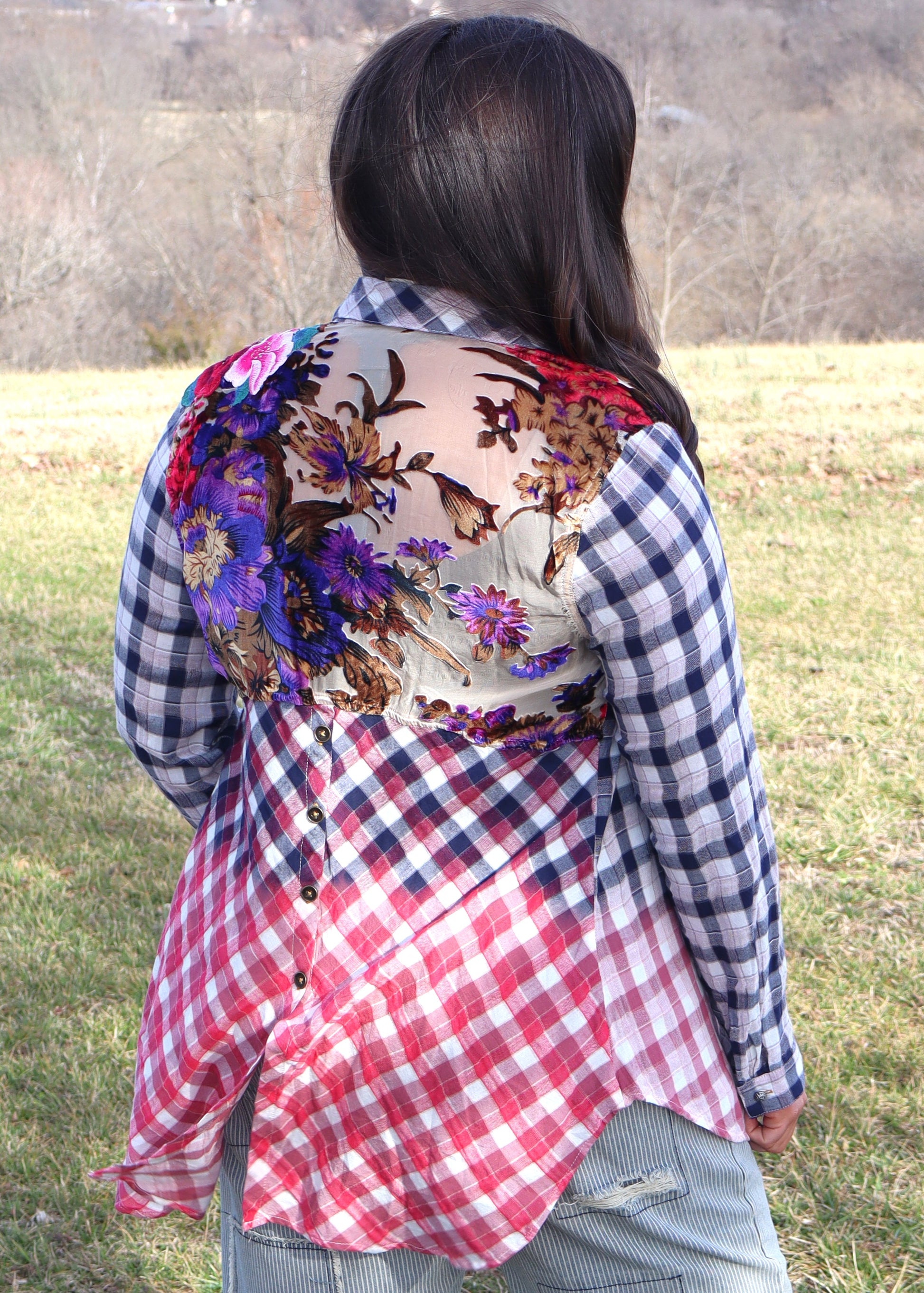 Woman wearing floral velvet applique-details on a plaid shirt with navy to red ombre effect while standing outside