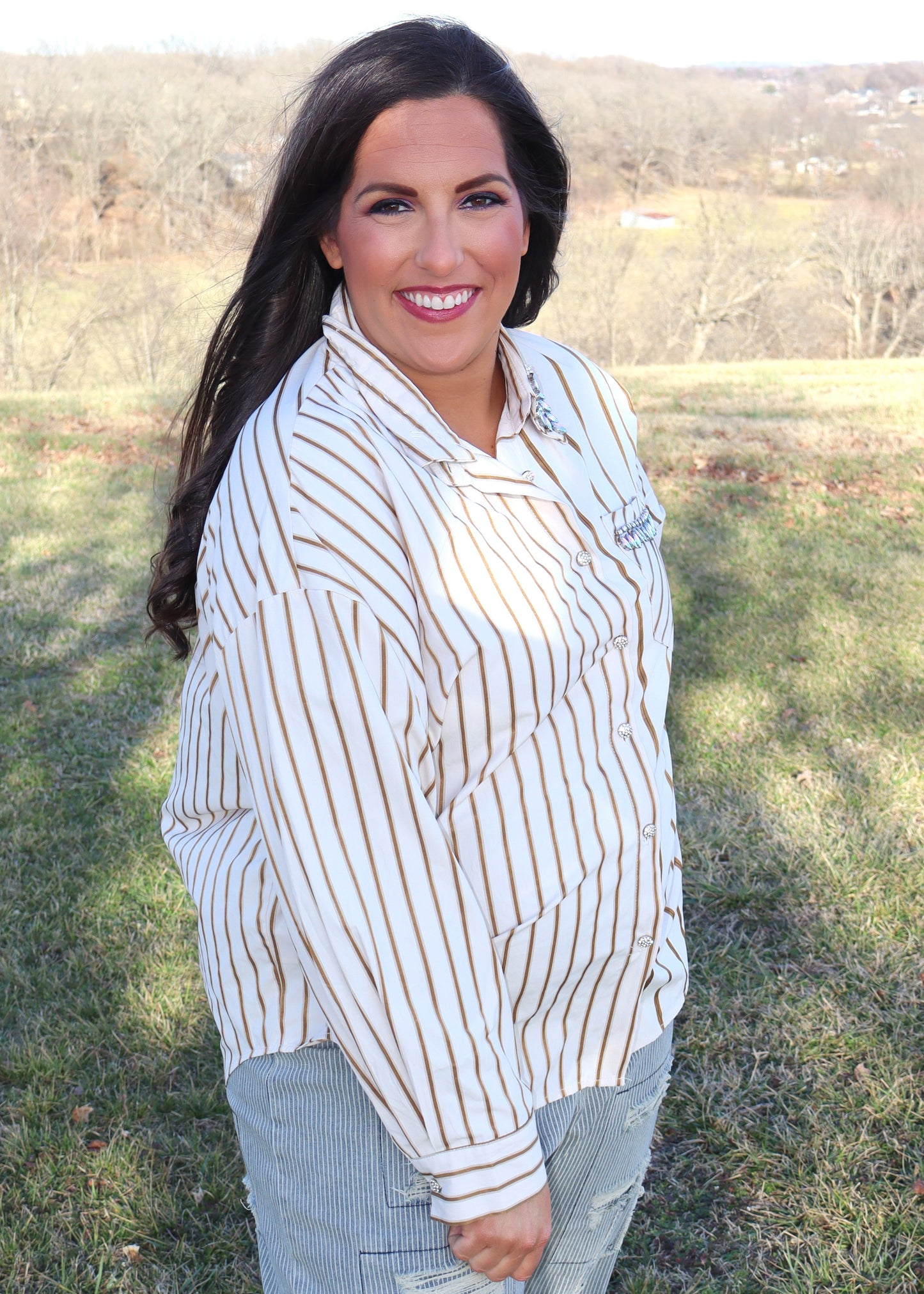 Woman wearing a striped shirt and jeans in an outdoor setting