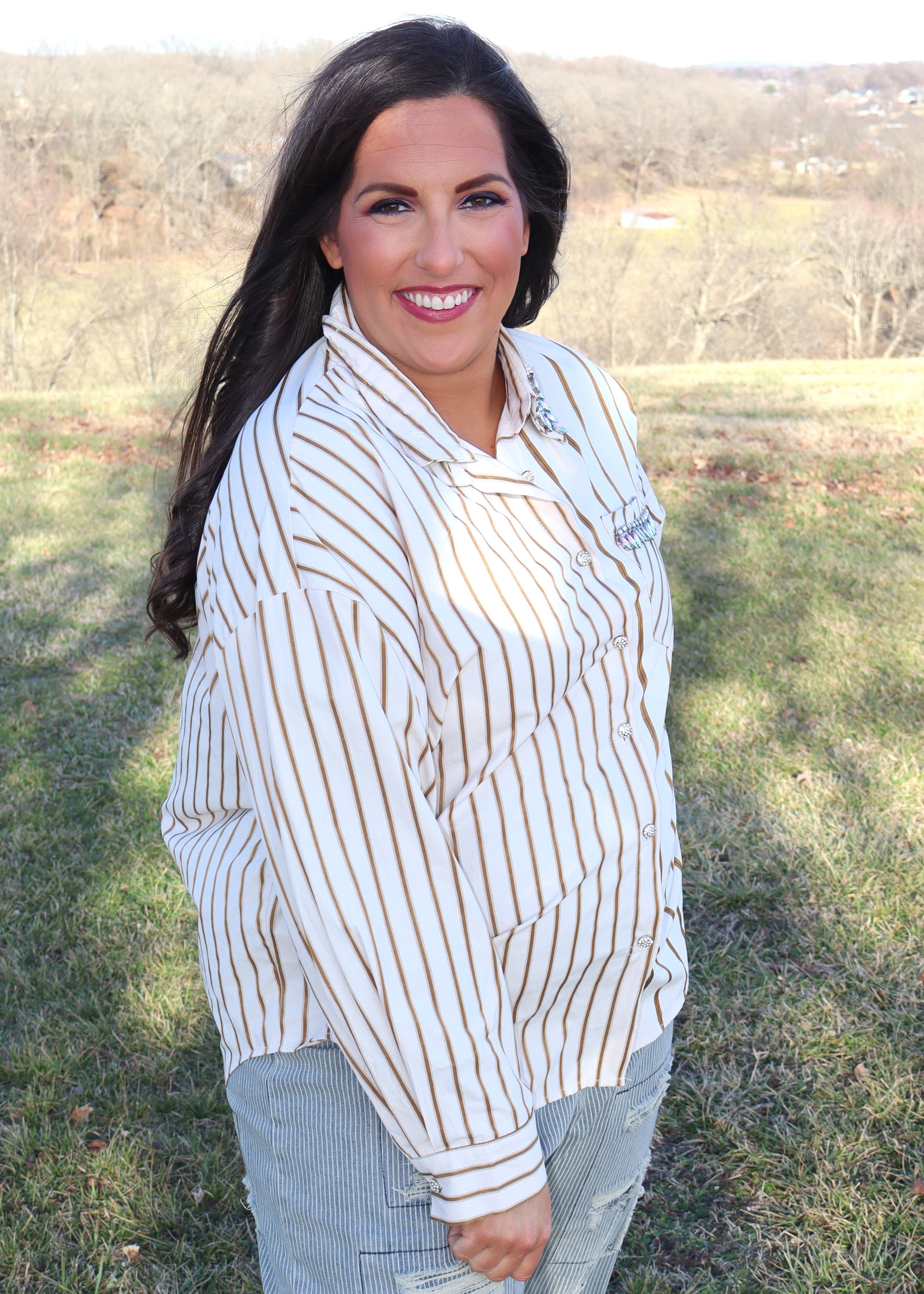 Woman wearing a striped shirt and jeans in an outdoor setting