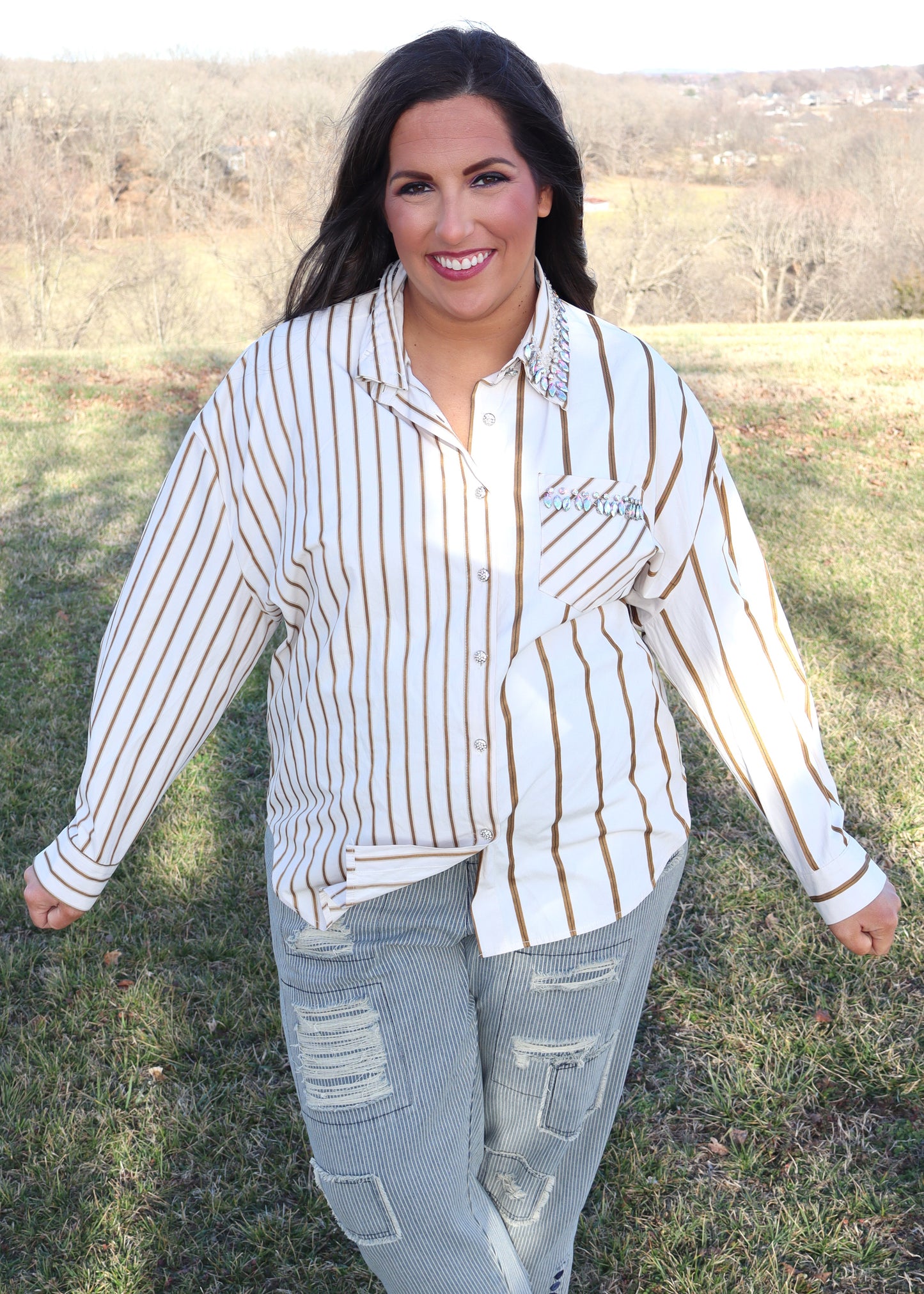 Woman wearing a striped shirt and jeans in an outdoor setting