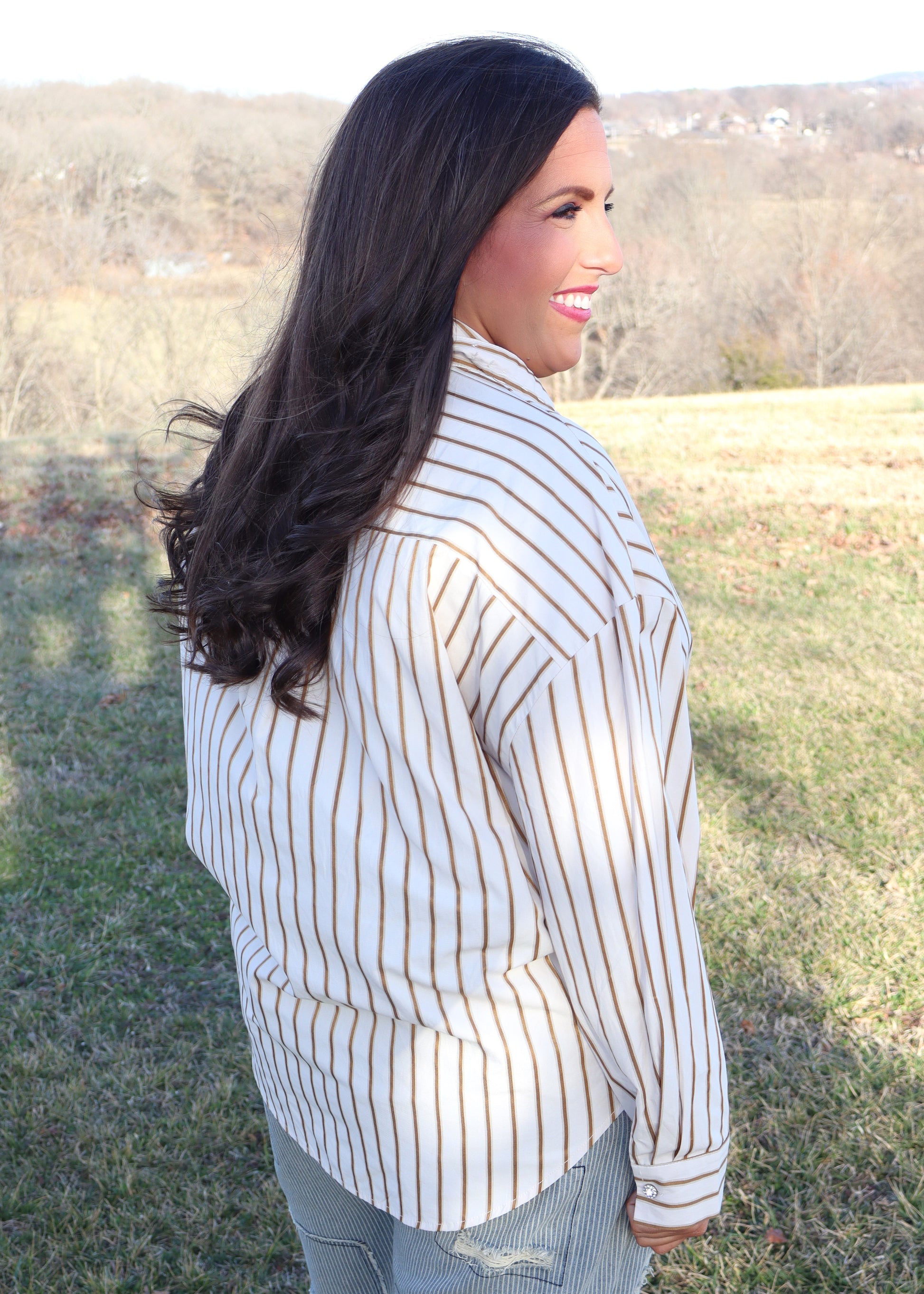 Woman wearing a striped shirt and jeans in an outdoor setting