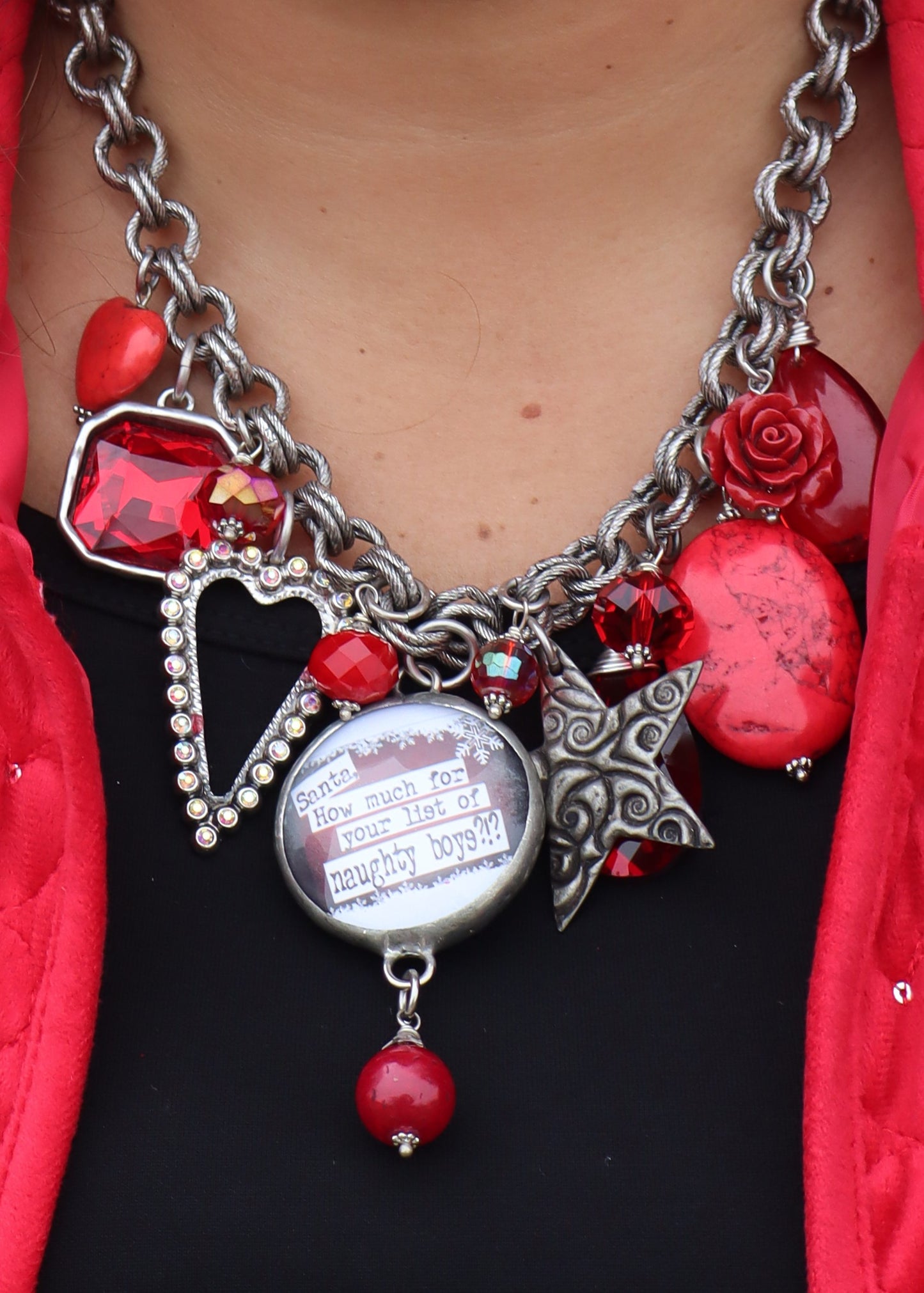 Santa necklace with a silver chain and red charms on a black background