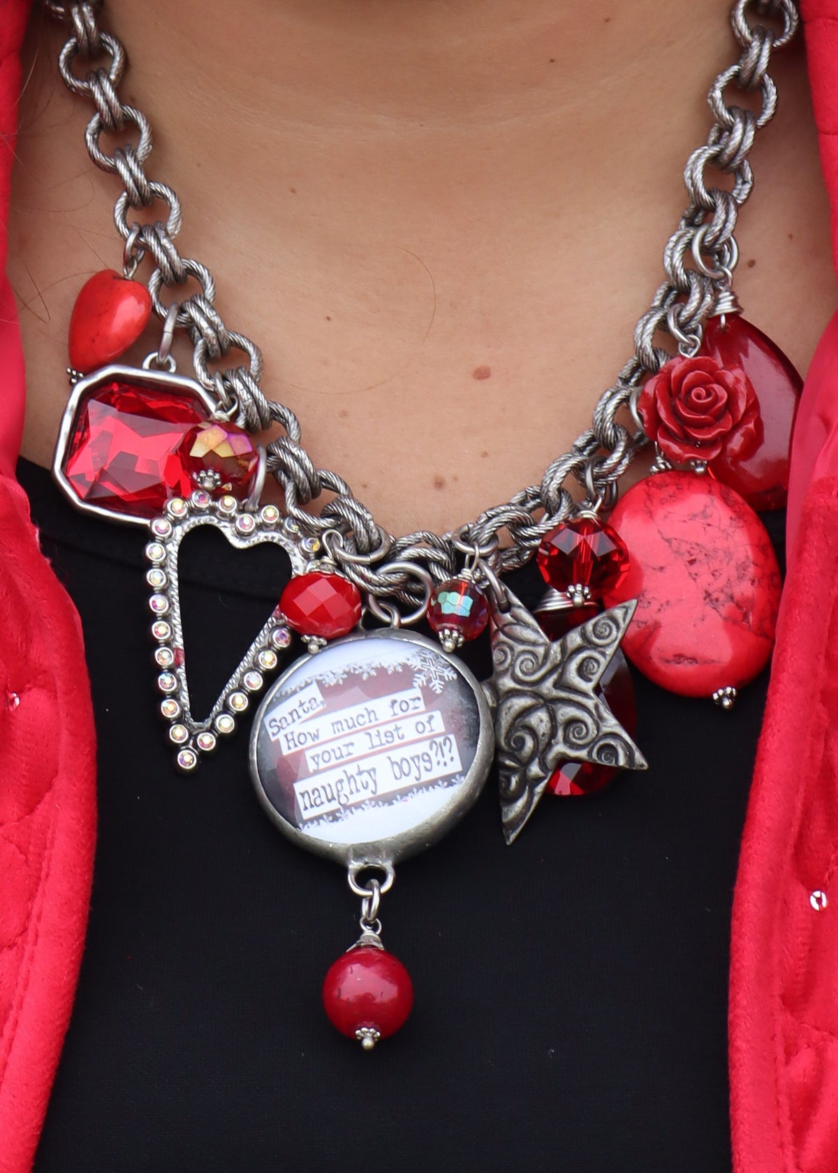 Santa necklace with a silver chain and red charms on a black background