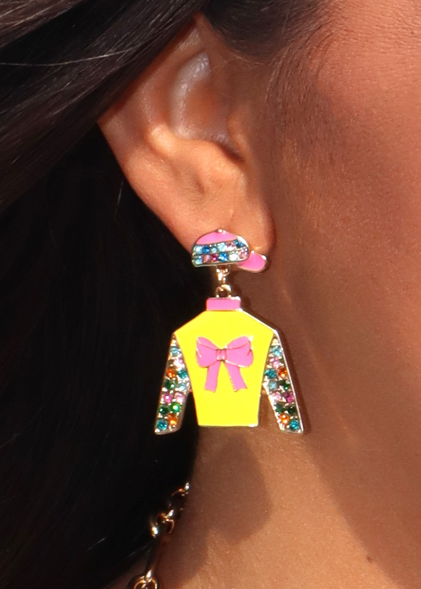 Bright yellow and polka dot jockey silk cutout stud earrings on a woman