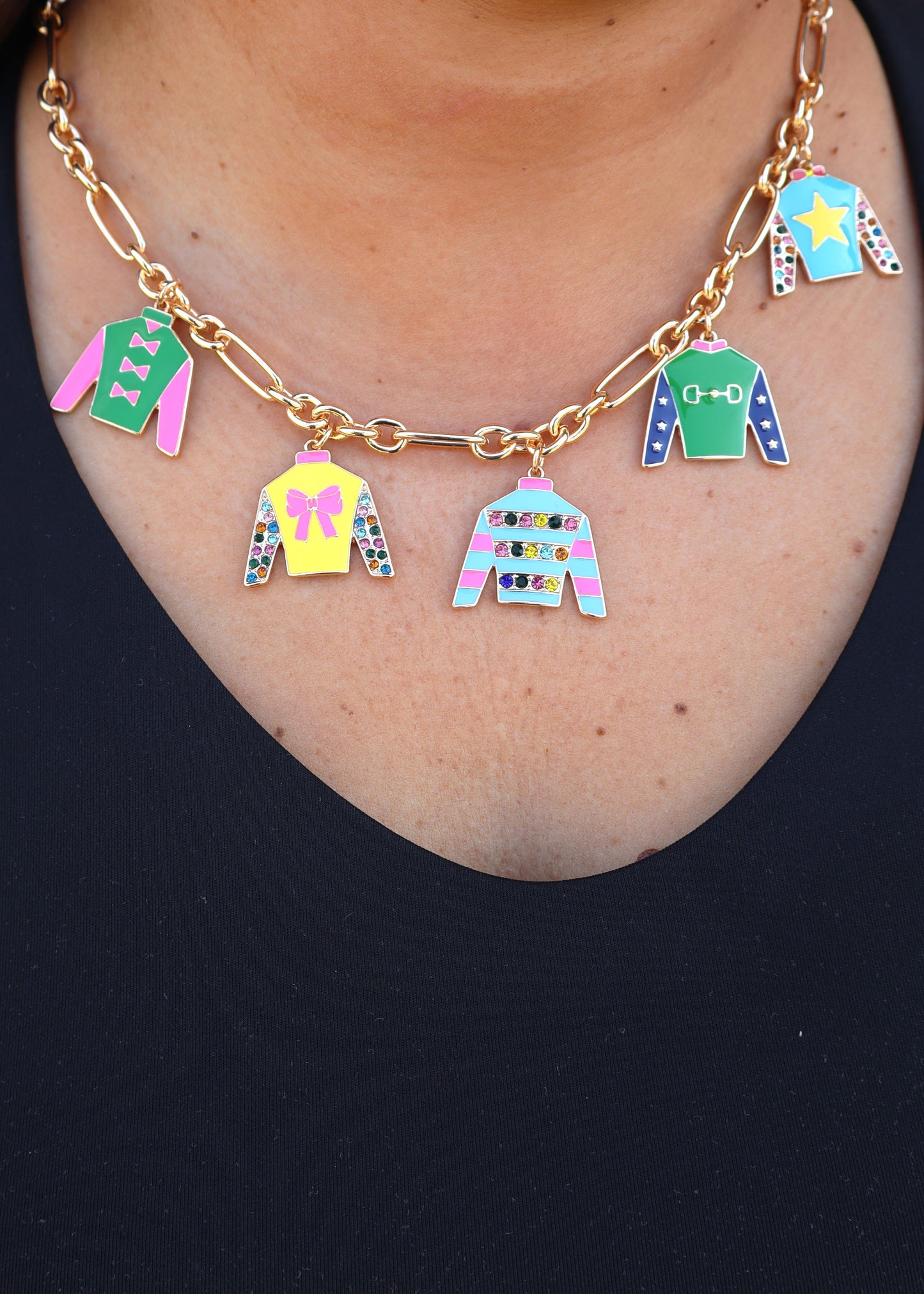 Gold chain necklace with colorful jockey silk cutouts on a woman